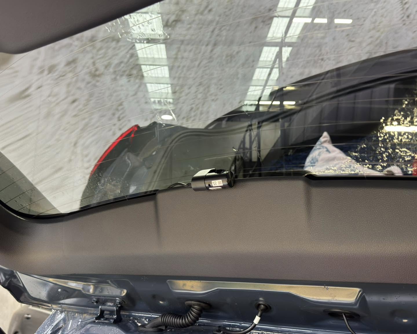 Compact rear dash camera installed inside a vehicle tailgate window